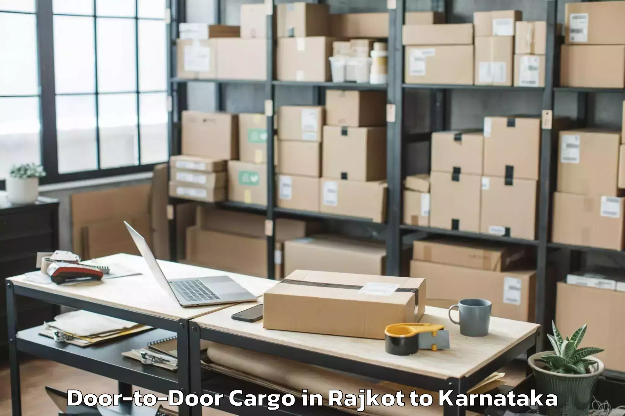 Top Rajkot to Karnataka Janapada Vishwavidya Door To Door Cargo Available